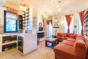 a living room with a couch and a kitchen at Villa Markella in Chrysi Ammoudia