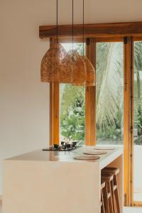 a kitchen with a counter top with a chandelier at Green Waves Villa in Batukaras