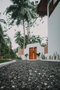 a house with a red door and palm trees at Green Waves Villa in Batukaras