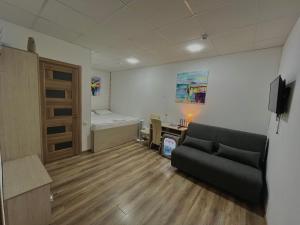 a room with a couch and a bed and a desk at Hotel BK in Kyiv