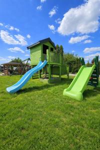 a playground with two slides in the grass at Apartamenty Welskie in Lidzbark