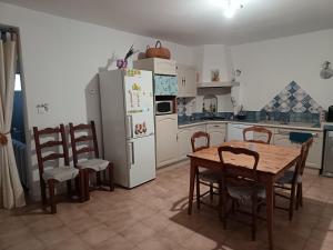 a kitchen with a table and chairs and a refrigerator at L'Escale Pernoise, 2-6 personnes in Pernes-les-Fontaines