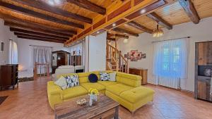 a living room with a yellow couch and a table at House Toni by Villas Guide in Brod Moravice