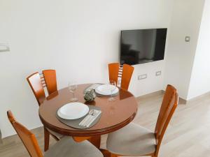 a dining room table with chairs and a television at Apartma Dana in Jadranovo