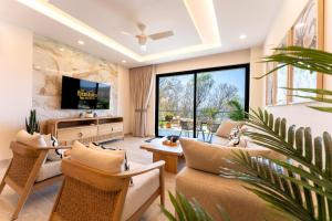 a living room with couches and a flat screen tv at 3101 - Paradise Cove 1A Violin in Tangolunda