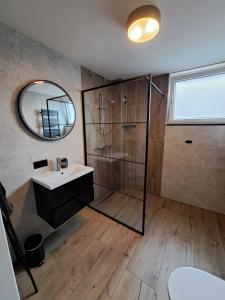 a bathroom with a shower and a sink and a mirror at AgterdeKoog in De Koog