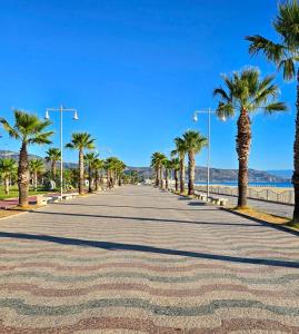 a road lined with palm trees on the beach at Blu Opèra Guest Rooms in Soverato Marina