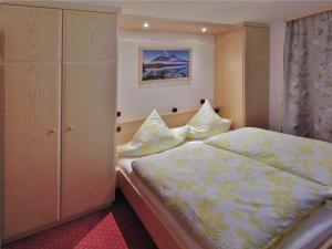 ein kleines Schlafzimmer mit einem Bett und einem Schrank in der Unterkunft Haus Frechen in Berchtesgaden