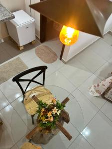 a living room with a glass table and a chair with flowers at Chalés Flor de Mandacaru in Monte das Gameleiras
