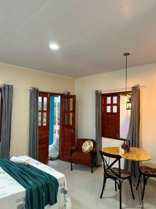 a bedroom with a bed and a table and a chair at Chalés Flor de Mandacaru in Monte das Gameleiras
