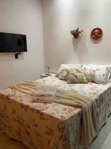 a bedroom with a bed with a tv on the wall at Chalés Flor de Mandacaru in Monte das Gameleiras