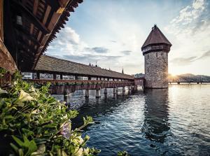 a bridge over the water with a tower on it at HOTEL ALPINA EINHORN - Self-Check-In in Wolfenschiessen