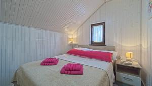 a bedroom with a bed with pink pillows on it at House Kiki by Villas Guide in Bosiljevo +35 photos