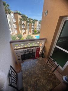 a balcony with a table and chairs on a building at Résidence Al kawtar, Mimosa Appartement in Ben Slimane