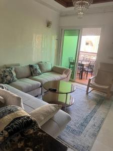 a living room with a couch and a table at Résidence Al kawtar, Mimosa Appartement in Ben Slimane +1 photo