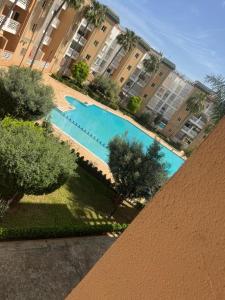 an overhead view of a swimming pool with buildings at Résidence Al kawtar, Mimosa Appartement in Ben Slimane
