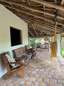 a living room with chairs and a flat screen tv at POUSADA e HOSTEL SÍTIO PARAÍSO DO CAJU in Barreirinhas