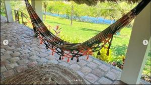 a hammock on a patio with a view of a yard at POUSADA e HOSTEL SÍTIO PARAÍSO DO CAJU in Barreirinhas +20 photos