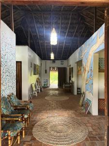 a living room with couches and a tree painted on the wall at POUSADA e HOSTEL SÍTIO PARAÍSO DO CAJU in Barreirinhas