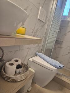 a bathroom with a toilet and a sink and towels at Villa Niki in Serifos Chora