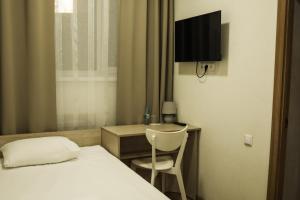 a hotel room with a bed and a chair and a desk at Hotel BK in Kyiv