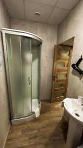 a bathroom with a glass shower and a sink at Hotel BK in Kyiv