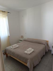 a bedroom with a bed with two towels on it at Residence La Duna in Castel Volturno