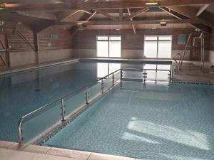 a large swimming pool in a building at Barmouth wave - Sunnysands Holiday Park caravan in Llanddwywe