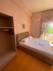 a bedroom with a large bed and a window at Bleta Residence in Sarandë