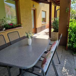 a table and chairs with a vase on a patio at Apartment Drejca in Kobarid
