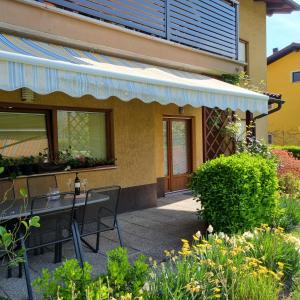 a patio with a table and chairs in front of a building at Apartment Drejca in Kobarid