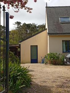 a house with a blue door in a driveway at Le studio des pins in Plouézec
