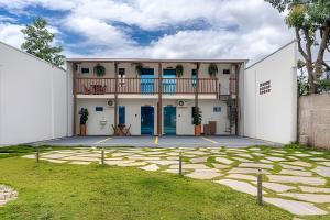 a large white building with a balcony at Recanto Sol da Chapada | Aptos no Centro com Garagem e Café da Manhã in Alto Paraíso de Goiás