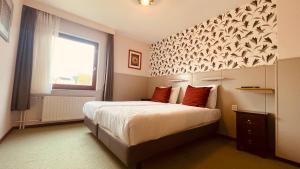 a bedroom with a large bed with a window at Hotel Heynen in Valkenburg