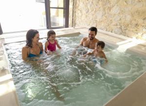 a family playing in a jacuzzi bathtub at Forest Within - Wellness Villa in Archanes in Káto Arkhánai