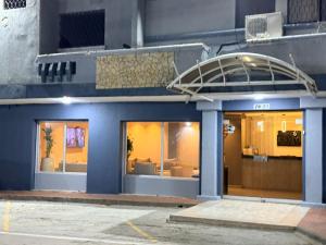 a blue building with windows and a round entry way at Hotel Exito Barranquilla in Barranquilla
