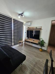 a living room with a large television and a couch at Apartamento Los Andes II in Los Andes