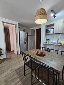 a kitchen and dining room with a wooden table and chairs at Apartamento Los Andes II in Los Andes