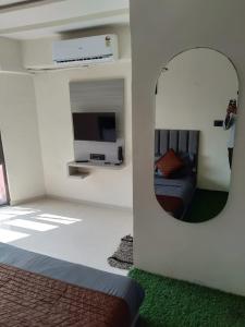 a person taking a picture of a bedroom with a mirror at HOTEL KONARK in in Vastral