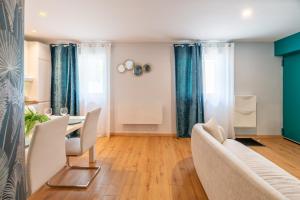 a living room with a table and chairs at Appartement la Perle in Ambérieu-en-Bugey