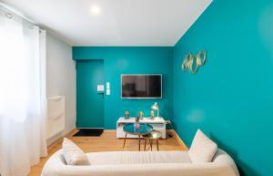 a living room with blue walls and a couch at Appartement la Perle in Ambérieu-en-Bugey