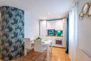 a kitchen and dining room with a white table and chairs at Appartement la Perle in Ambérieu-en-Bugey