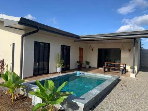 a swimming pool in front of a house at Villa Shambala Arenal Volcano View Private Pool 6 Guests in Tanque
