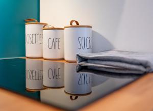 a row of coffee cups with the words justice coffee and a towel at Appartement la Perle in Ambérieu-en-Bugey +32 photos