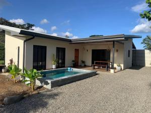 a house with a swimming pool in front of it at Villa Shambala Arenal Volcano View Private Pool 6 Guests in Tanque