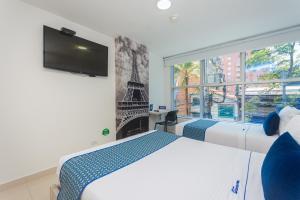 a bedroom with a bed and a large window at Hotel Laureles Plaza in Medellín