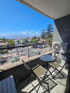 a balcony with a table and chairs and a view of a city at Apartamento Los Andes II in Los Andes