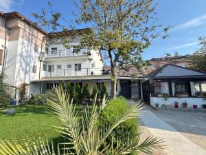 a white house with a tree in a yard at Vila Ana Trident Costinesti in Costinesti