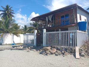 a house on the beach with a fence at Cabaña los recuerdos de ella in Moñitos +34 photos