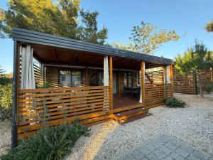 a log cabin with a porch and a deck at GoLD mobile homes D&L in Biograd na Moru